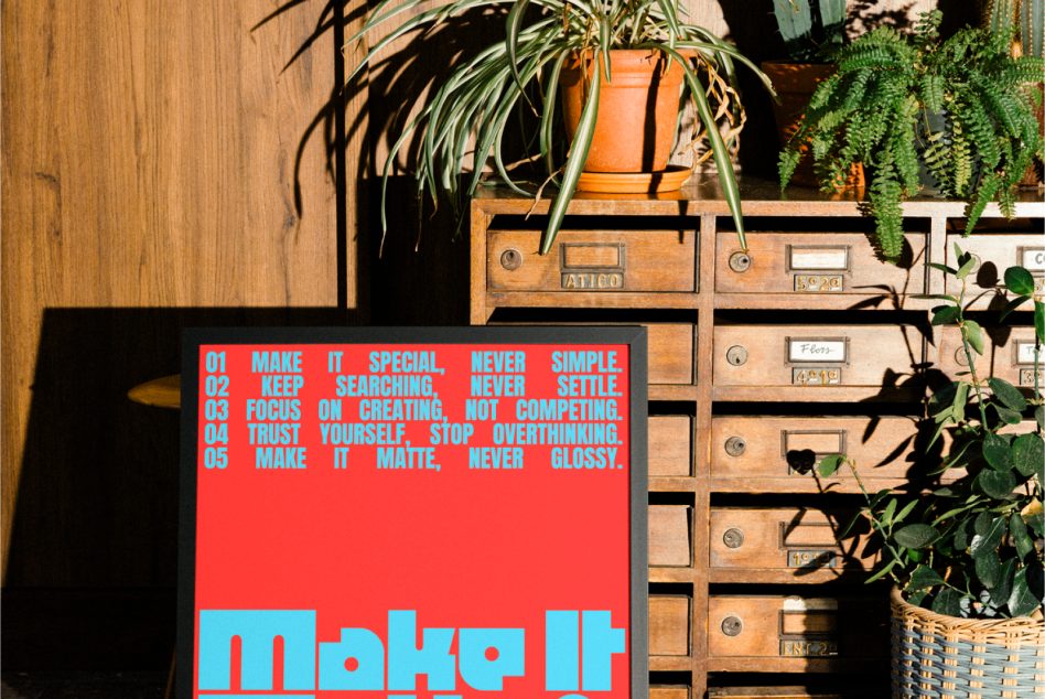 Red poster with cyan text displaying five design principles next to wooden apothecary cabinet with trailing succulents