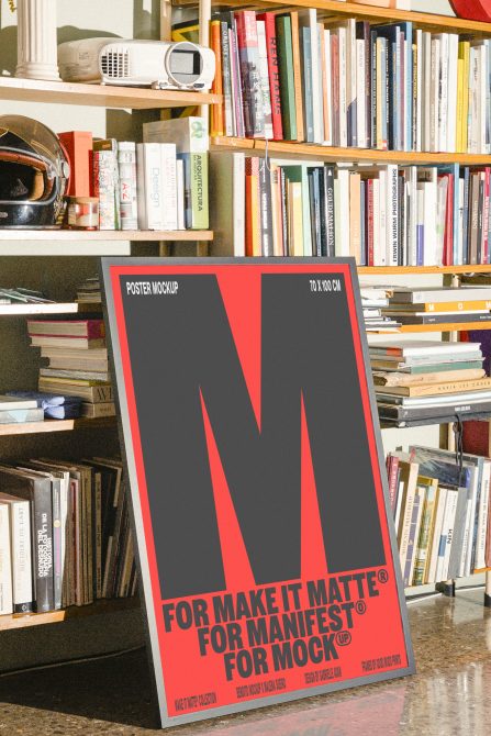 Red 70x100cm poster mockup propped against colorful bookshelf display