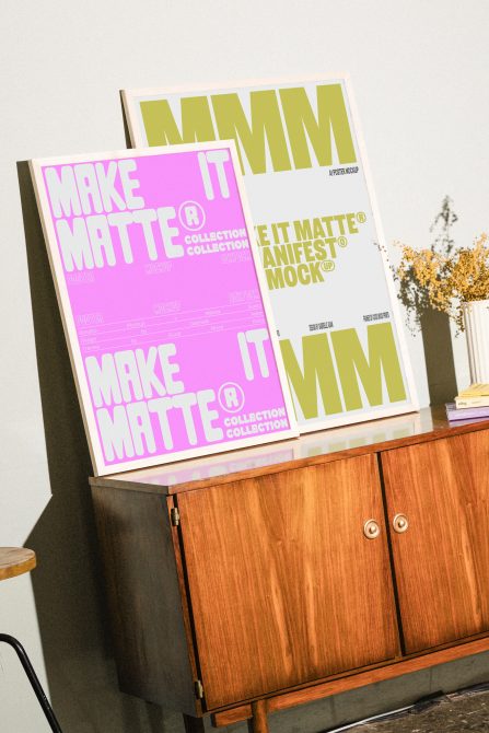 Two A2 posters on wood cabinet displaying pink, yellow color variations of matte mockup template