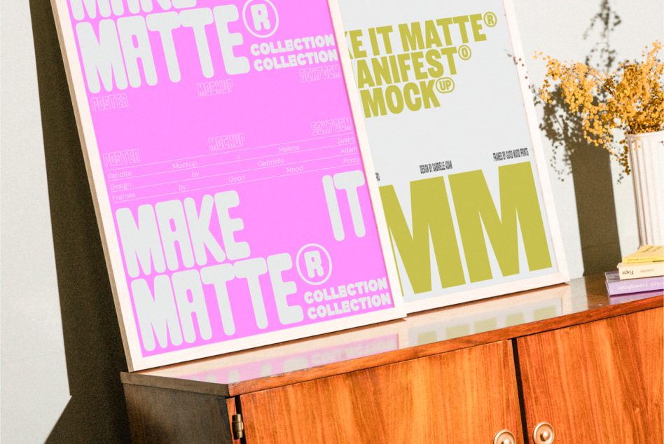 Pink, yellow colored A2 posters leaning on wood cabinet showing matte mockup in different hues