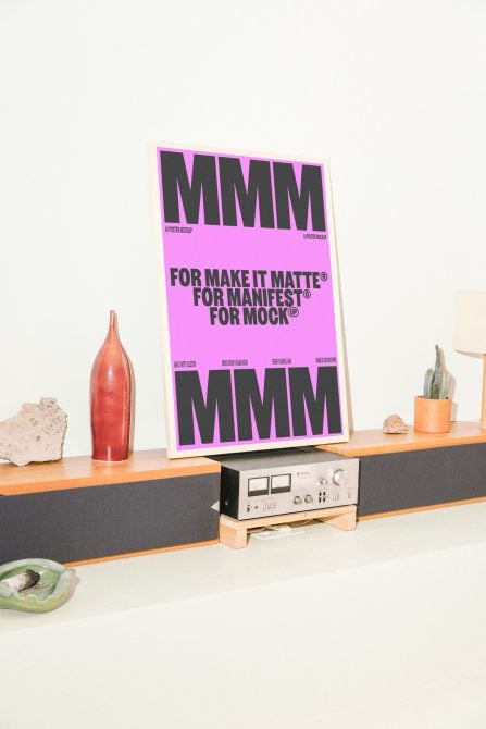 Bright magenta poster mockup displayed on shelf next to red bottle decor