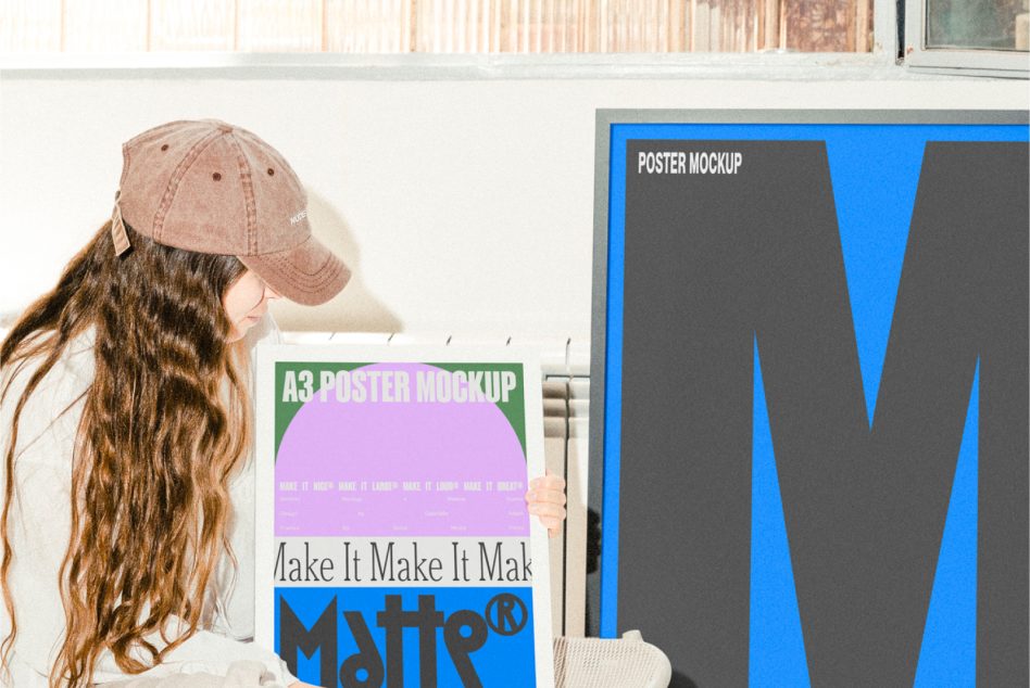 Woman holding green A3 poster mockup next to blue W poster on white wall