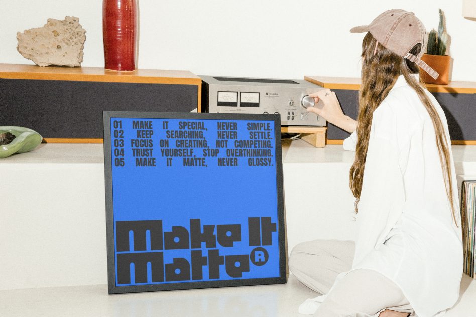 Poster mockup with motivational text. Designer in white shirt and cap adjusts vintage audio equipment. Keywords: poster mockup, motivational, designer, vintage.