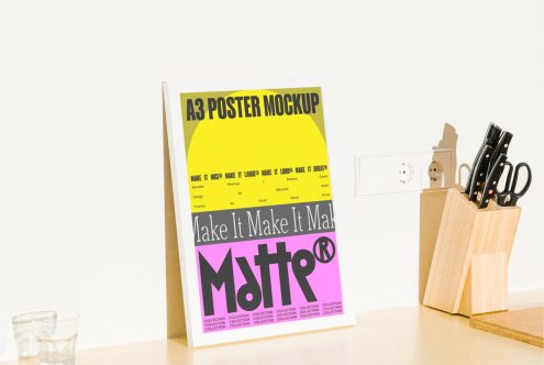 A3 poster mockup template on a wooden stand on a designer's desk featuring colorful typography perfect for showcasing poster designs to graphic designers and artists