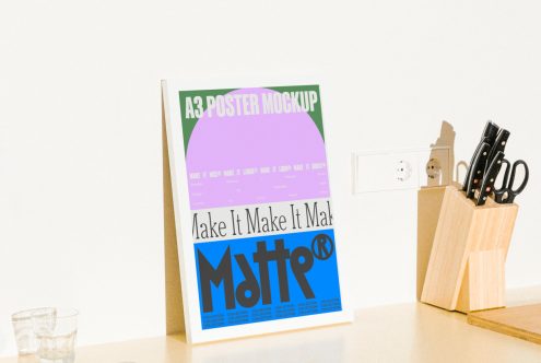 A3 poster mockup featuring bold typography and colors, placed on a desk with kitchen utensils. Perfect for designers. Keywords: mockups, templates, graphic design.