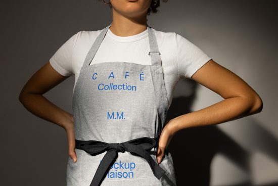 Mockup of cafe apron with blue text worn by person in white shirt. Ideal for designers seeking apron design templates. SEO keywords cafe apron design mockup.