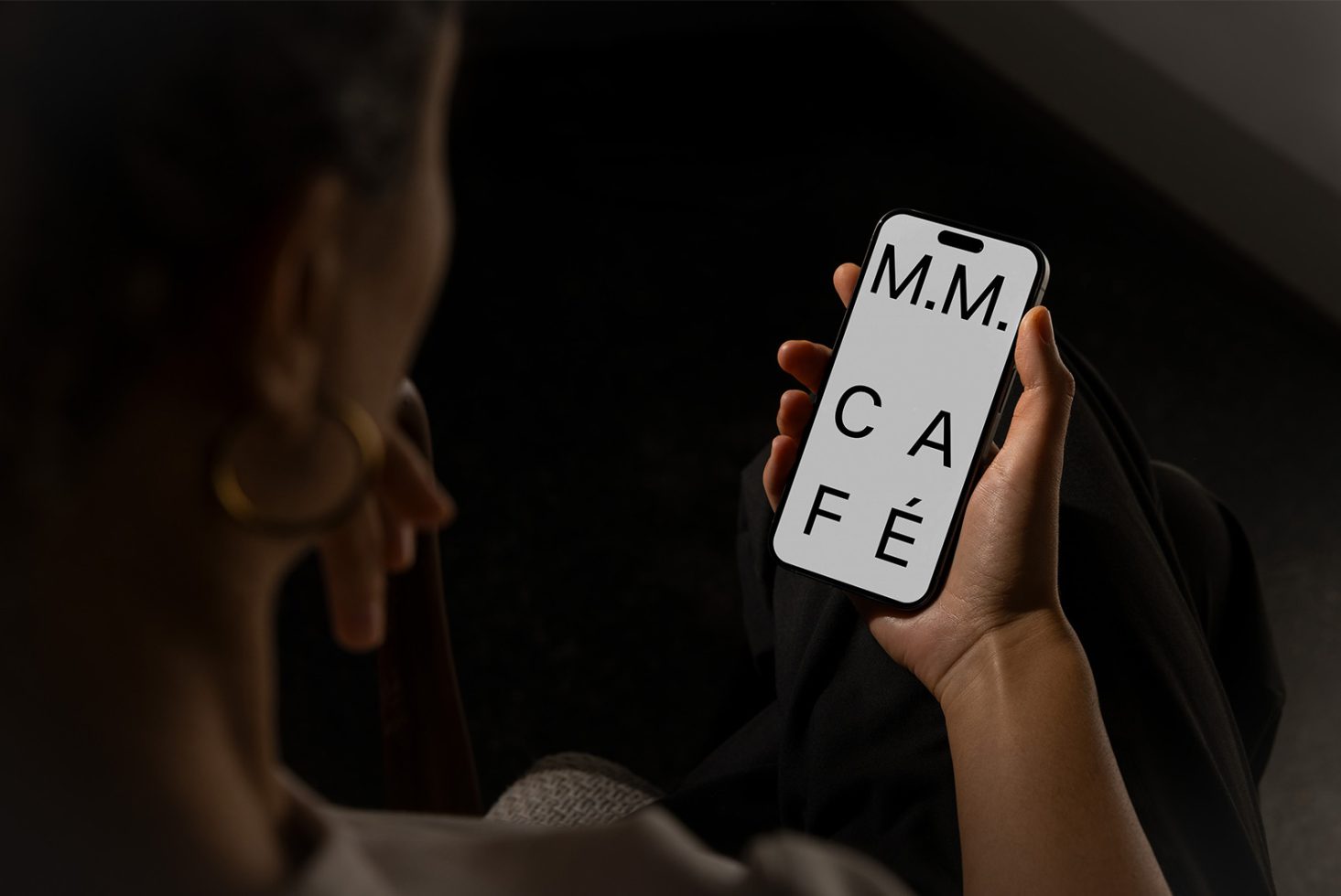 Person holding smartphone with large typographic text M M Cafe luxury font design SEO digital templates for designers modern visual mockup graphics for marketplace