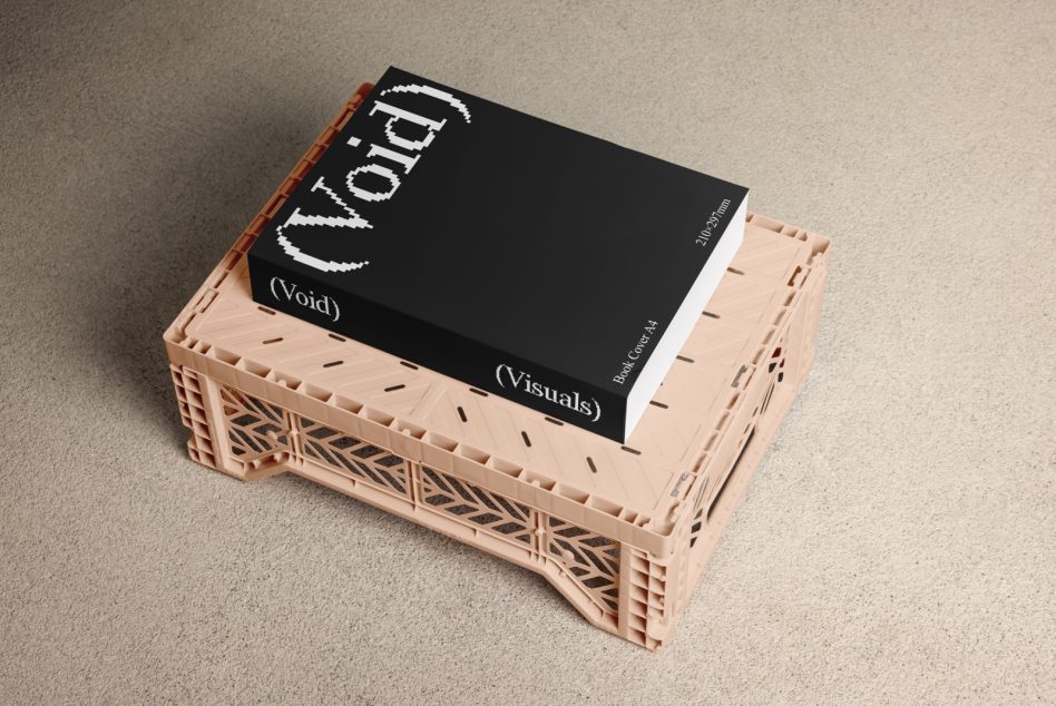Book sitting on peach plastic crate with geometric patterns, black cover with white pixelated typography