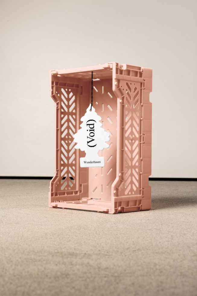 Pink plastic crate with tree-shaped air freshener that reads Void Wunderbaum inside. Suitable for mockups, digital assets for designers, SEO keywords mockup and template.