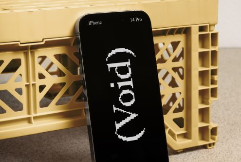 iPhone 14 Pro mockup leaning on a yellow plastic crate. Display shows the text World in a pixelated font. Ideal for designers and digital mockup assets.