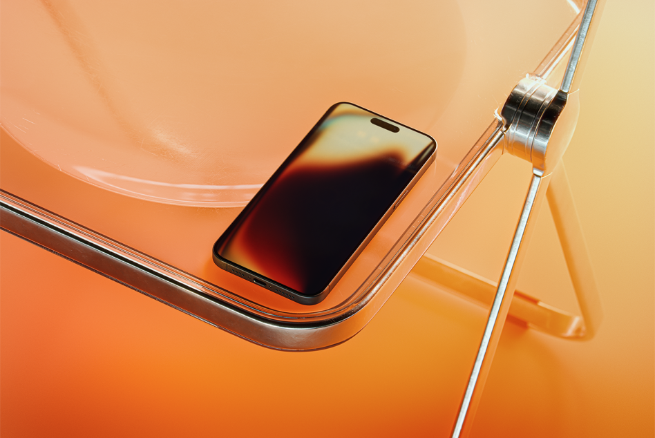 High-quality smartphone mockup on a modern transparent orange chair, perfect for showcasing app designs or UI concepts. Ideal for designers creating mobile templates.