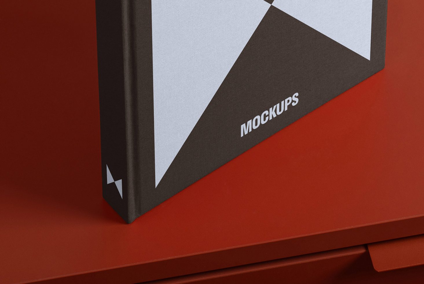 Book cover with modern geometric design and the word mockups on a red surface, ideal for designers needing stylish mockup templates for digital asset presentation