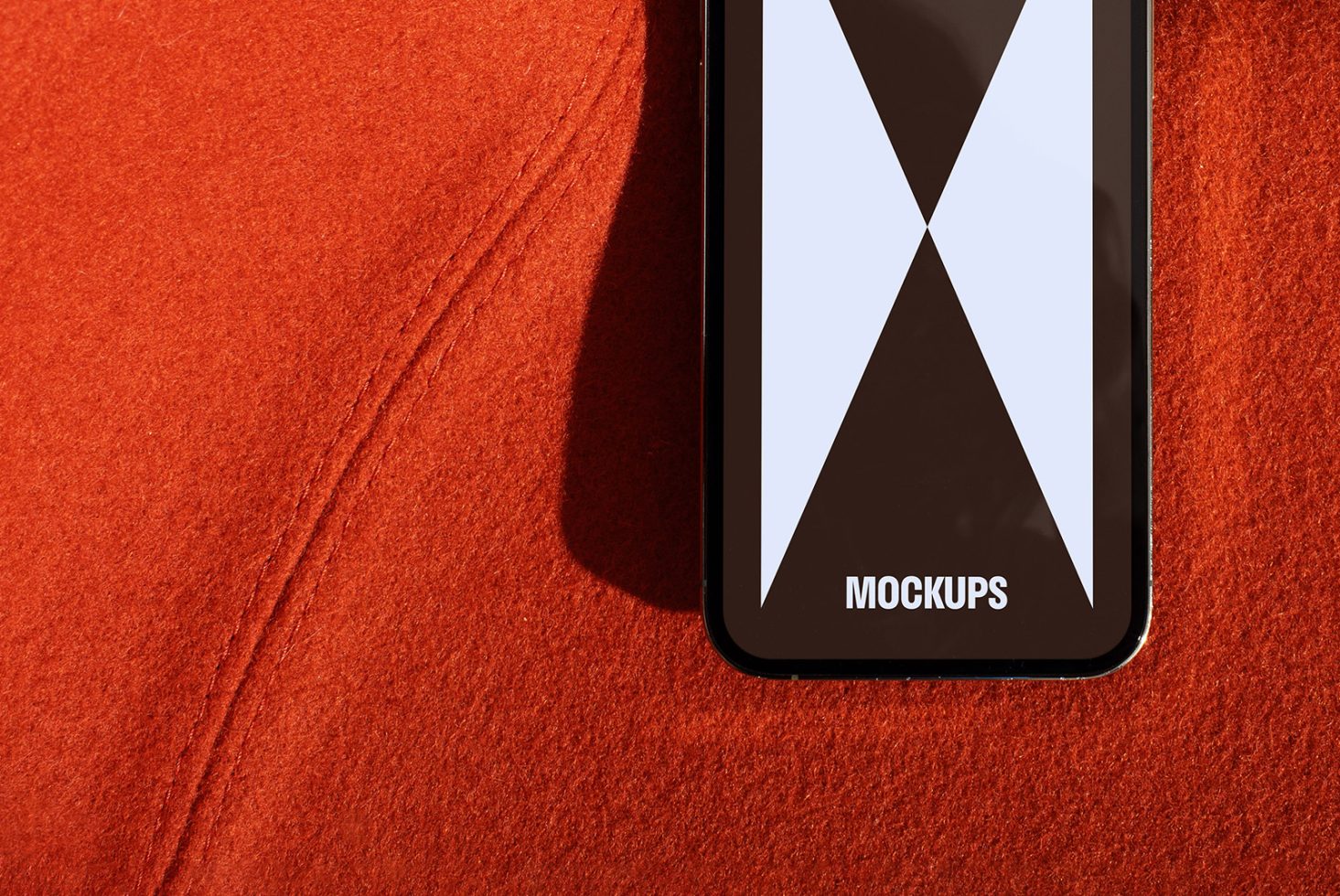 Smartphone screen showing the word Mockups on a red textured background perfect for designers looking to create stylish and modern product mockups for templates.