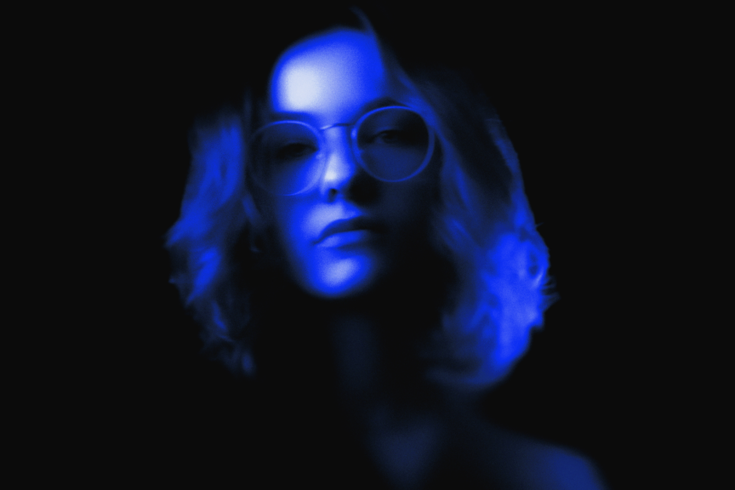 Blue neon portrait of a woman wearing glasses with a dark background. Great for digital graphic assets, creative templates, artistic visual mockups.