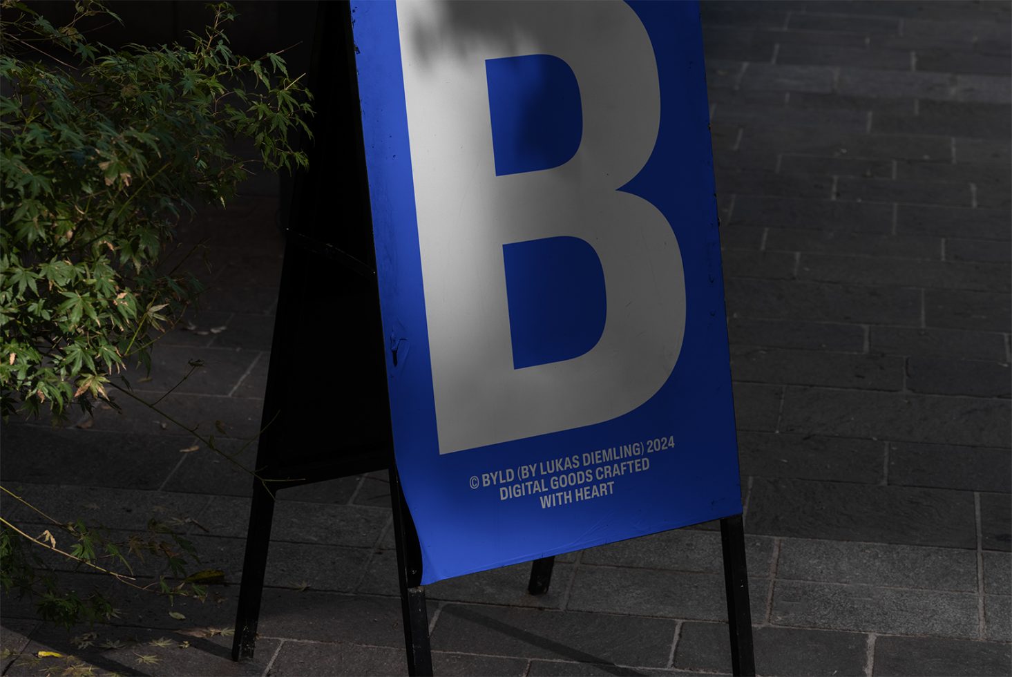 Outdoor signboard mockup with a large white letter B on a blue background, suitable for showcasing branding and promotional materials for designers.