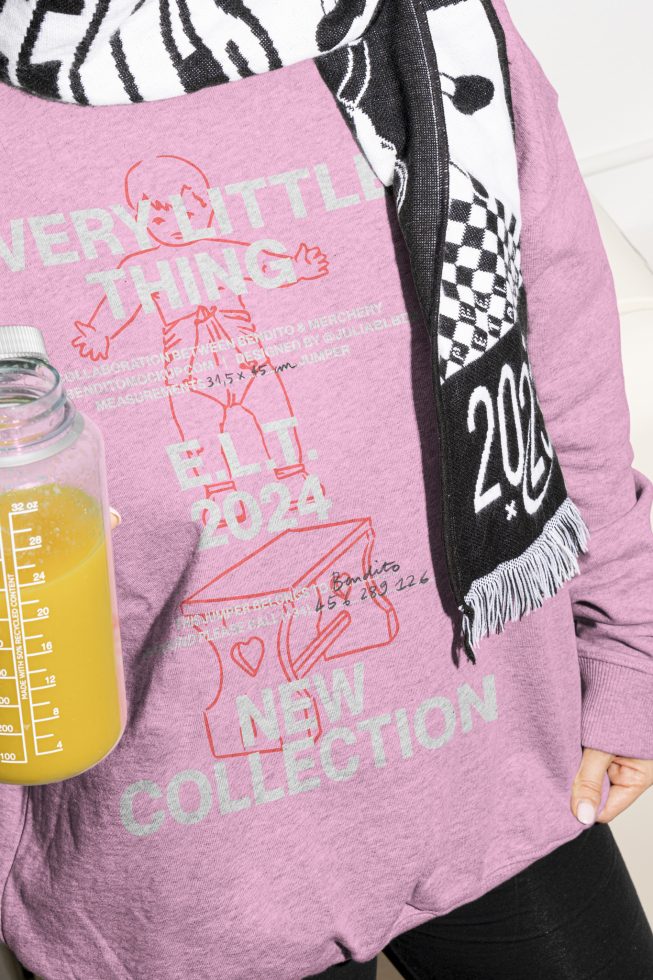 Close-up of a person wearing a pink t-shirt with graphic text and holding an orange juice bottle. Ideal for Mockups, Graphic Assets, Apparel Design Templates