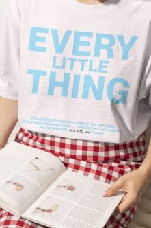 White oversized tee with blue Every Little Thing text red gingham pants holding magazine