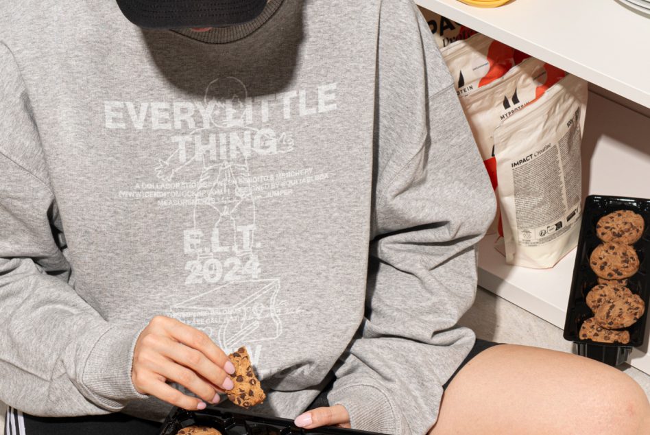 Casual gray sweatshirt mockup showing text print design with a person holding cookies. Perfect for apparel design presentations for digital assets in mockups.