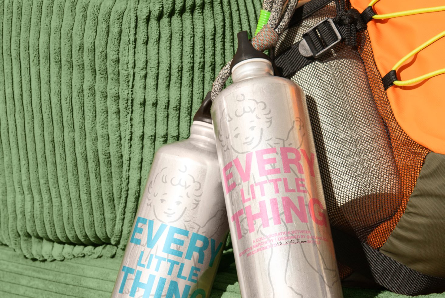 Aluminum water bottles with text Every Little Thing on green and orange gear. Perfect for advertising outdoor mockups, templates, and graphic design assets.