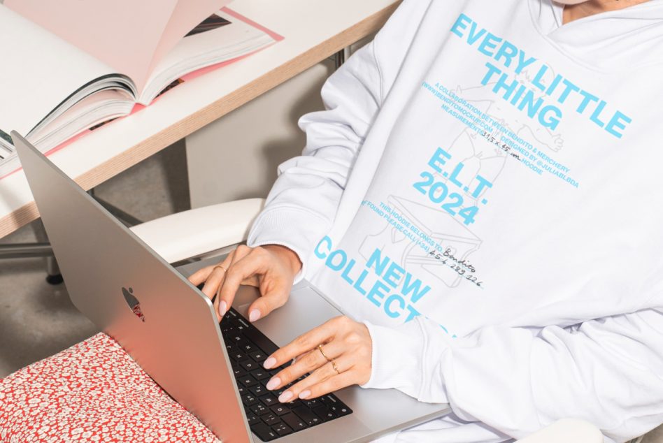 White hoodie worn during work session at laptop with geometric red fabric