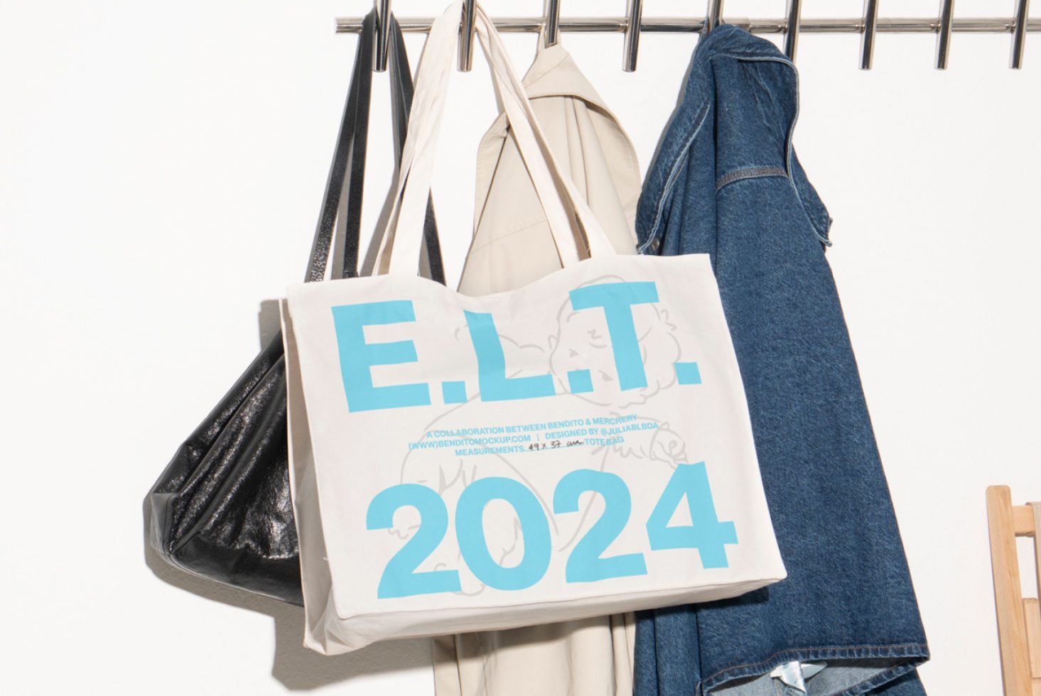 Canvas tote bag mockup with text ELT 2024 hanging among jackets suitable for graphic designers branding templates and digital assets SEO friendly