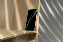 Colorful refracted light on phone display inside natural wood shelf unit