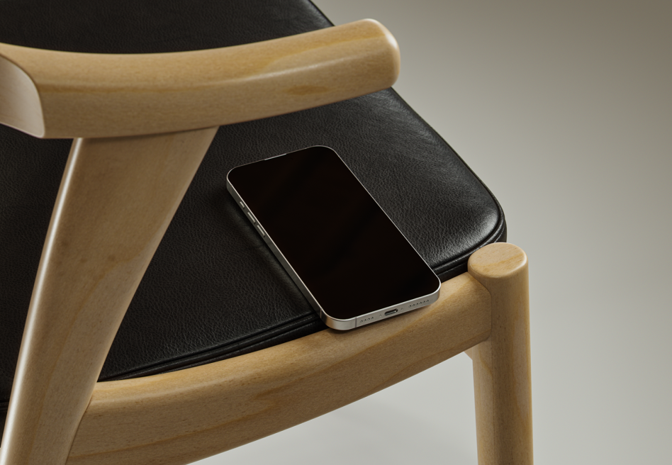 Mockup of a smartphone on a modern wooden chair with black leather seat. Perfect for showcasing digital designs and templates for designers. Mockups, phone mockup.