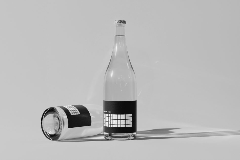 Glass bottle mockup with black label, shown upright with cap plus laying glass on neutral background