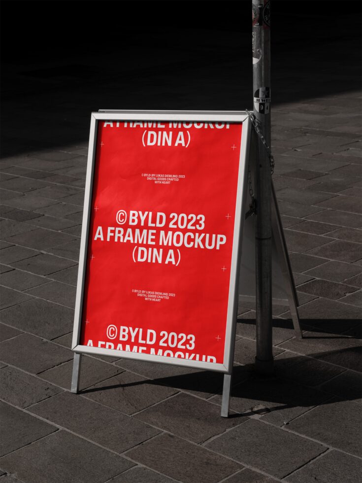 A frame mockup with a red poster displayed on a sidewalk. Ideal for showcasing advertising designs. Keywords: mockup, template, A-frame, design.