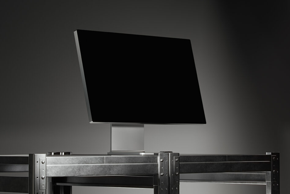 Wide-screen computer monitor mockup on industrial metal desk in a dimly lit studio setting ideal for designers. Keywords: mockup, monitor, design, template.