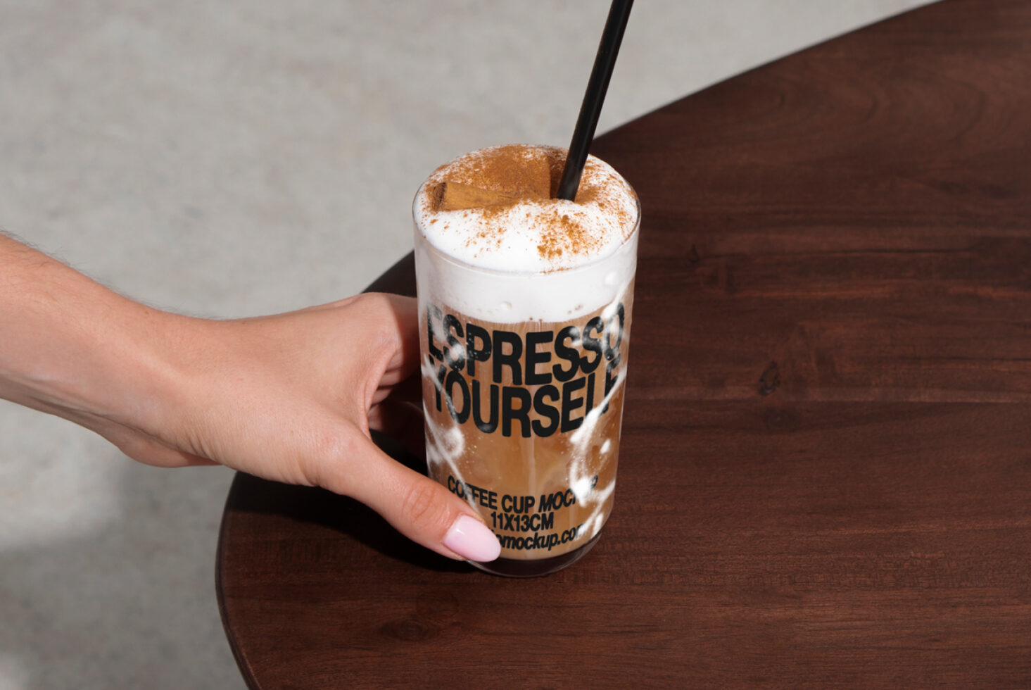 Hand holding a coffee cup with frothy topping on wooden table mockup design template. Ideal for branding designers or café graphics SEO keywords: mockup template coffee cup design branding graphics.