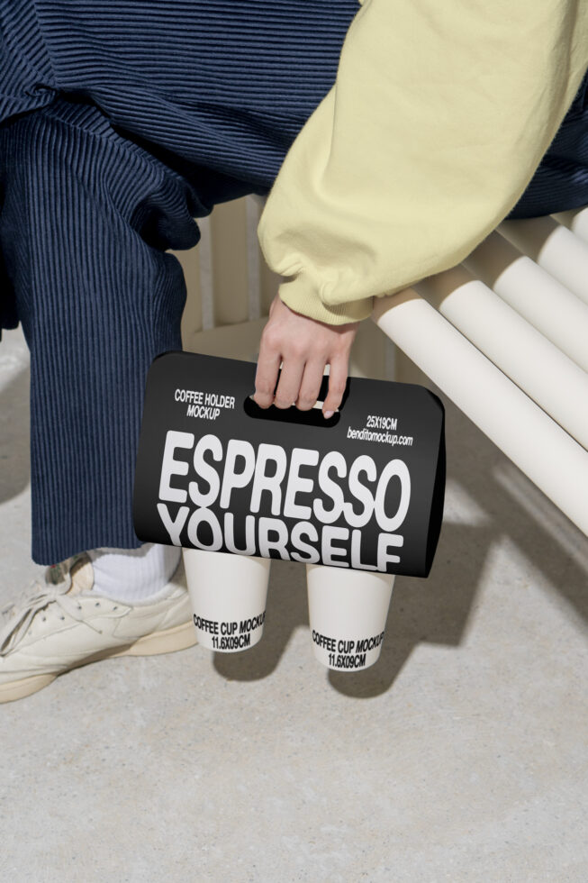 Coffee holder mockup with bold text Espresso Yourself held by hand. Ideal for designers seeking realistic branding mockups. Trendy marketing graphics.