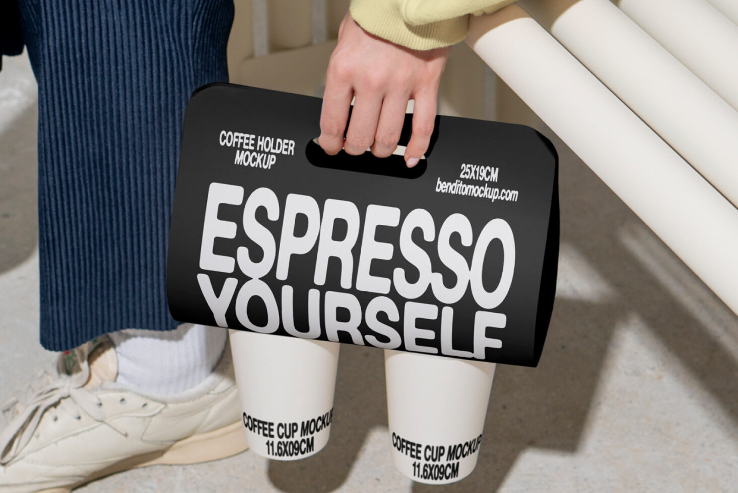 Designer holding a coffee cup holder mockup with bold text Espresso Yourself Perfect for graphic design templates and branding mockups in creative projects.