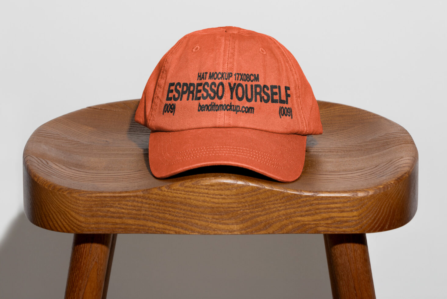 Orange cap mockup on a wooden stool for branding designs or apparel templates. Perfect for showcasing logo designs. Ideal for designers.