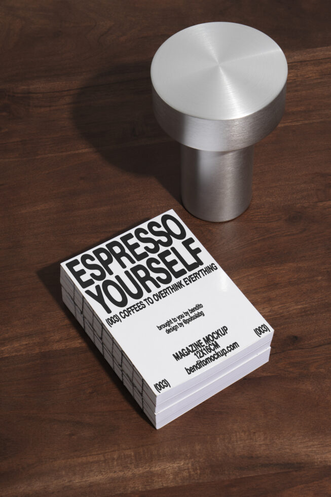 Magazine mockup on brown wood surface featuring bold typography Espresso Yourself alongside a modern metallic decor piece ideal for designers' presentations.