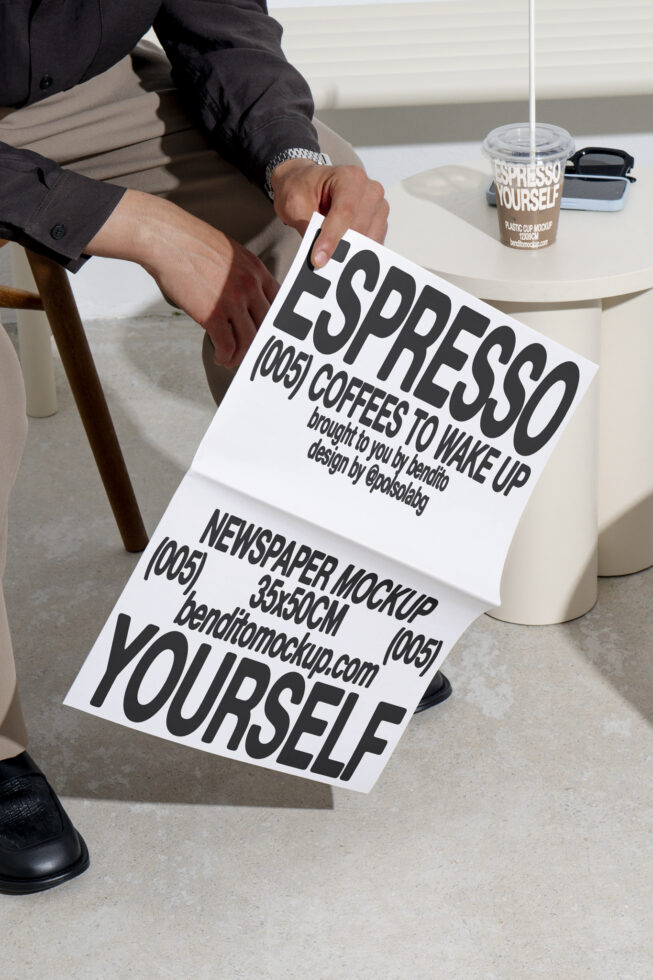 Person holding a newspaper mockup design with bold typography, showcasing branding for coffee. Ideal for designers seeking stationery mockups, templates.