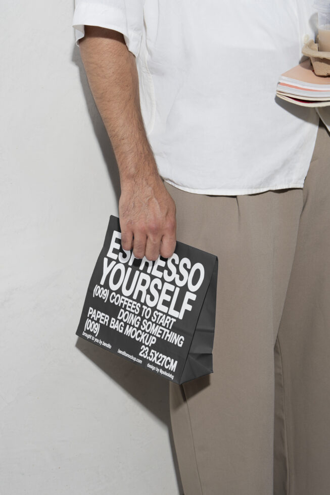 Man holding a paper bag with espresso design text closeup mockup. Ideal for branding packaging templates for designers. Neutral background.