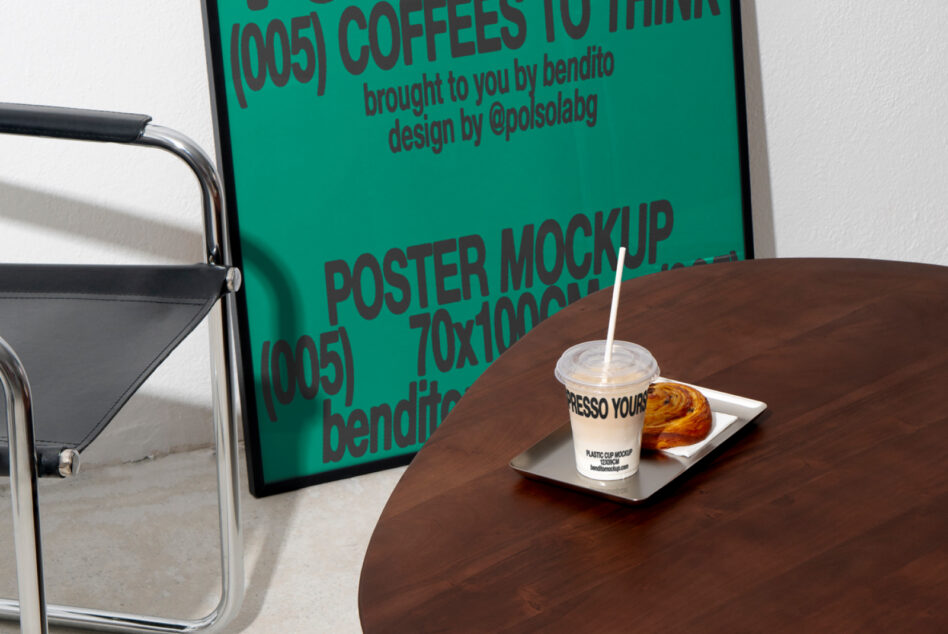 Designer setup with poster mockup leaning against a wall beside a metal chair and table holding iced coffee cup and pastry. Keywords: mockup, design, poster.