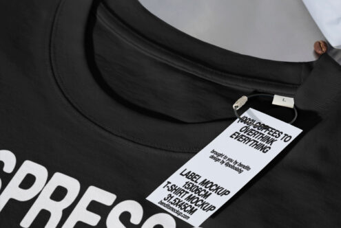 Black t-shirt mockup with a tag for design. Perfect for designers looking for realistic apparel mockup. Keywords: mockup, t-shirt, design asset.