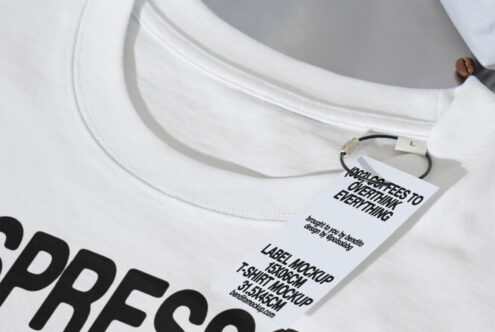 White T-shirt mockup with custom label tag, ideal for fashion designers. Detailed fabric texture and tag design, perfect for showcasing apparel graphics.