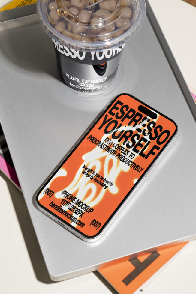 iPhone mockup with bold typography on the screen beside a plastic cup on a tray; ideal for designers and digital presentations; showcases modern graphics