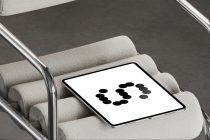 Tablet on gray upholstered chair arm showing dots in ring layout