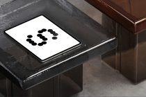 Tablet on weathered dark table with brown furniture showing dot pattern