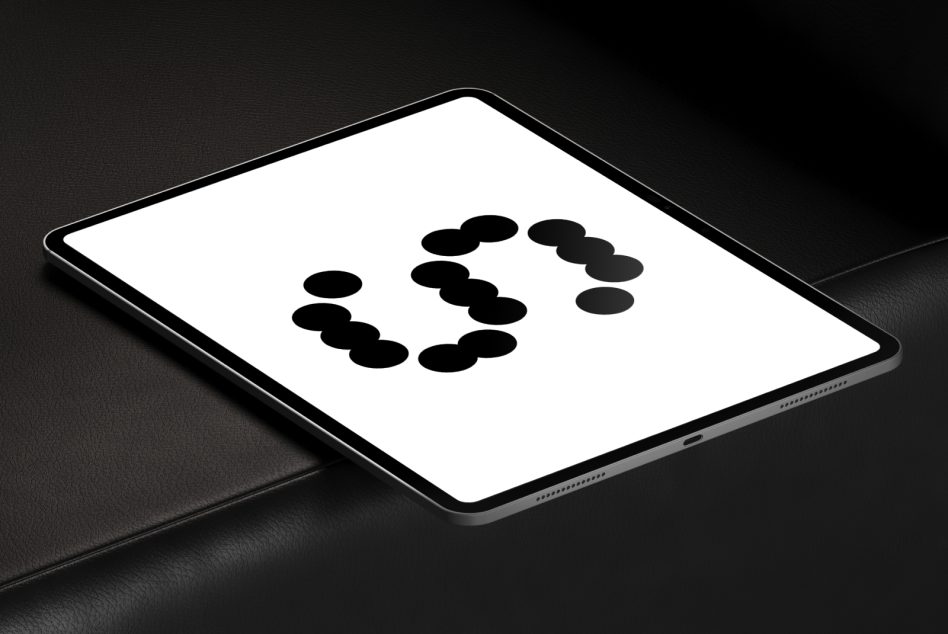 Tablet on dark surface showing circle of black dots arranged in ring pattern