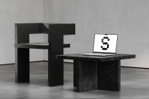 Laptop displaying dotted number 3 next to modern black chair