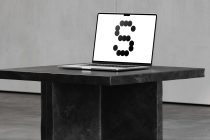 Laptop on concrete desk showing number 3 made of black circles