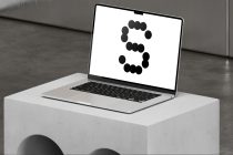 White laptop on marble pedestal displaying number 3 in black dots