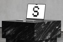 Laptop on dark marble desk with number 3 composed of black dots
