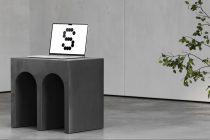 Laptop on concrete pedestal displaying number 3 with trailing plant branches