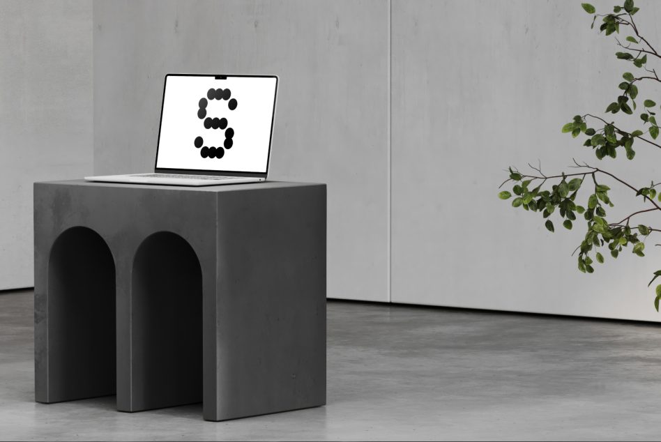 Laptop on concrete pedestal displaying number 3 with trailing plant branches